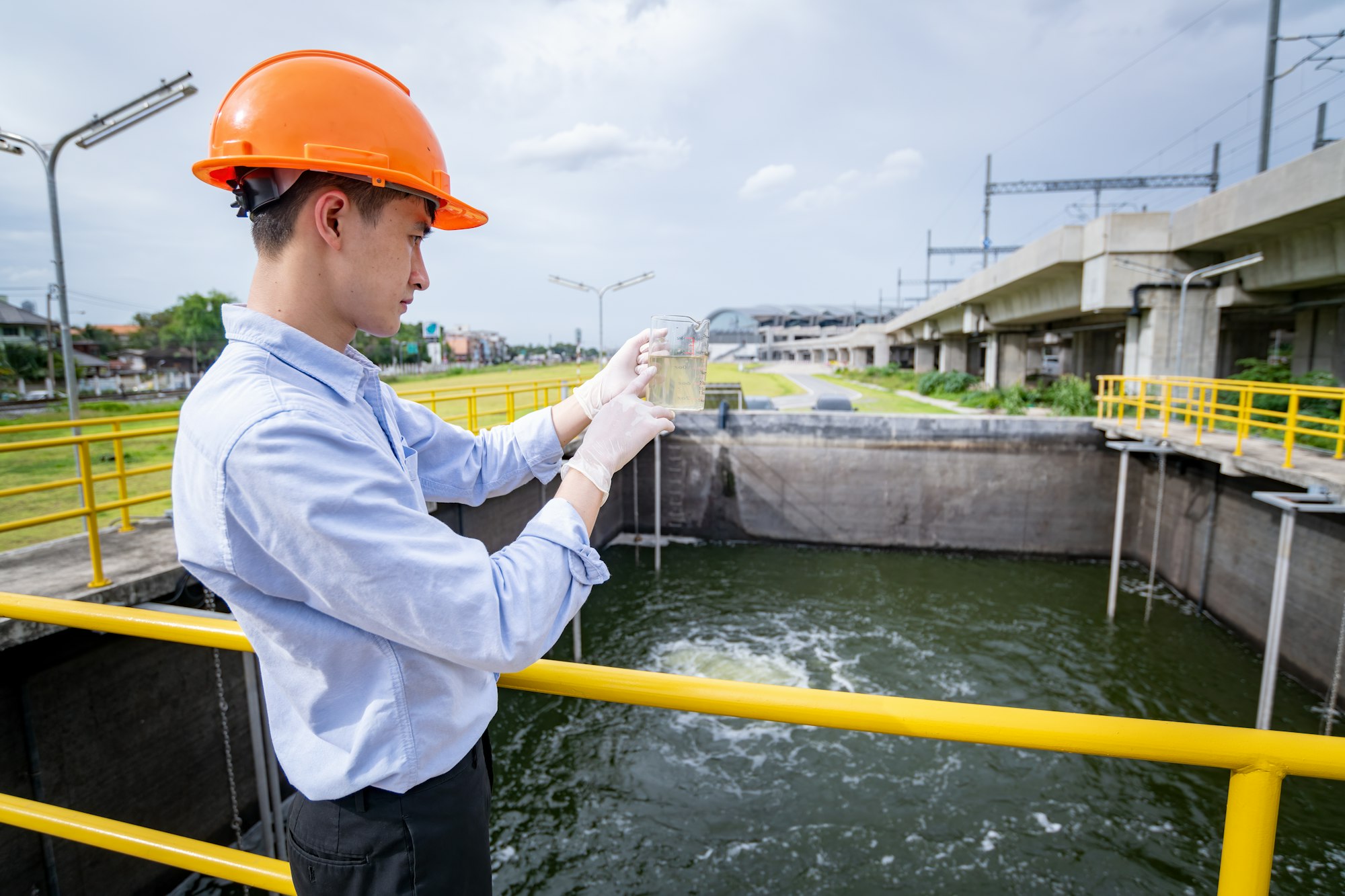 Engineer take water from wastewater treatment pond to check the quality of the water. After going th